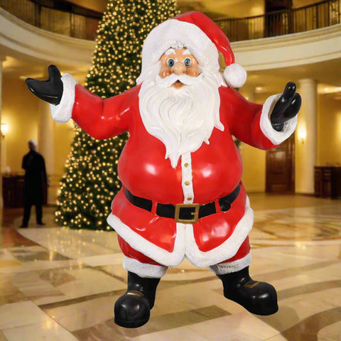 A statue of Santa Claus holding a teddy bear in one hand and a lantern in the other, dressed in traditional red and white attire.