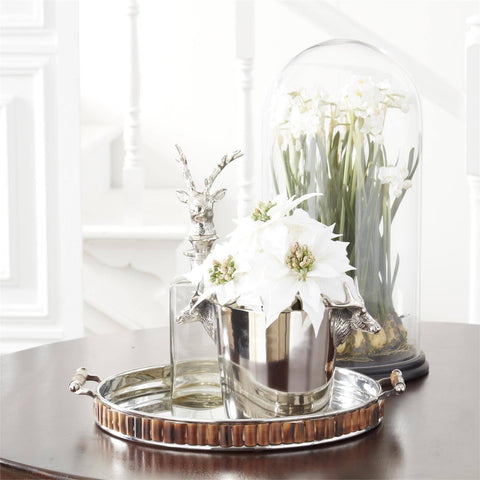 A sophisticated tabletop arrangement featuring a glass cloche covering a display of artificial white flowers.