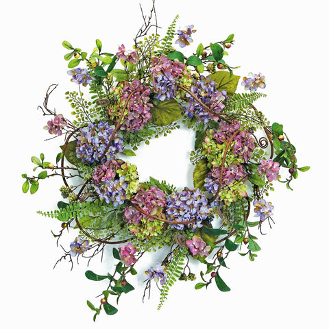 A circular floral wreath made of purple and pink Hydrangea flowers intertwined with green foliage and branches on a white background.