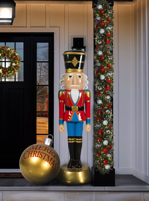 A statue of Santa Claus in his traditional red suit and hat, with white trim, black boots, and a black belt, has arms raised and an open-mouthed expression.