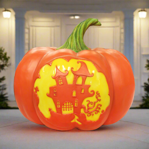 Decorative pumpkin with light, with a haunted house design in yellow.